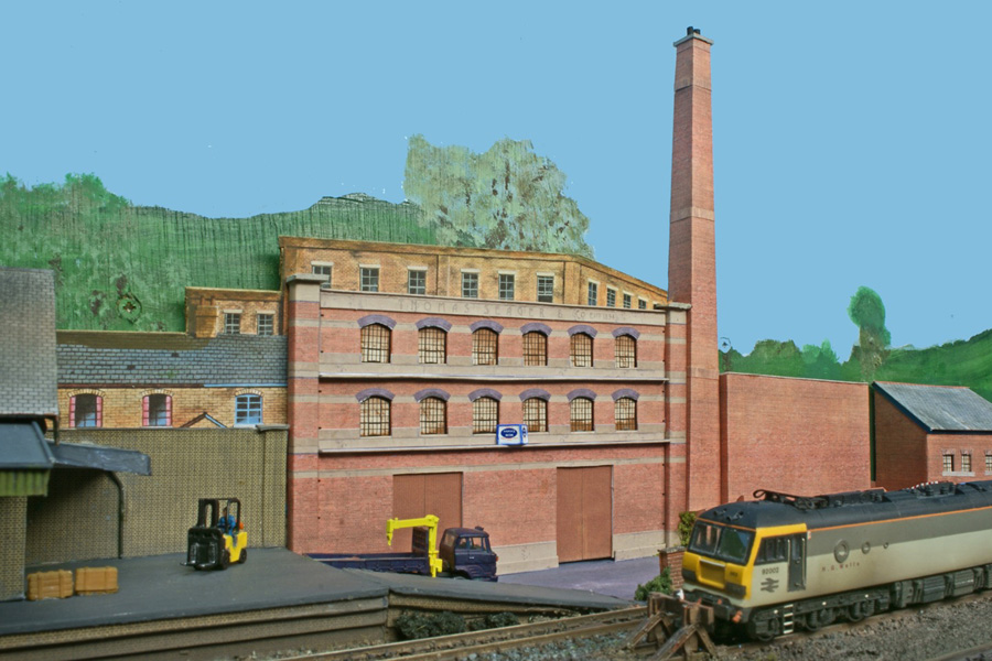 A Class 58 in Mainline livery takes a special pipe load out of the station while the branch line DMU service awaits a departure in the opposite direction.